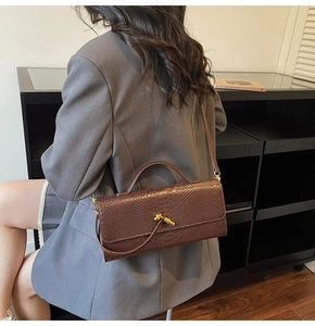 Vue détaillée d'un sac à main marron avec texture serpent et fermoir métallique doré