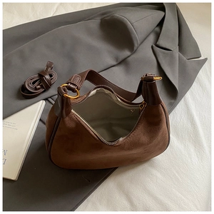 Detailed macro view showing interior lining and gold hardware of brown suede hobo bag
