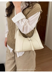 Elegante borsa hobo color crema abbinata a un gilet beige per un look retrò chic