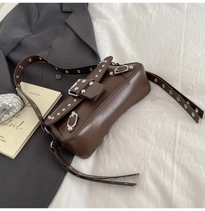 Detailed view of deep brown Y2K leather bag with silver rivets and eyelet shoulder strap