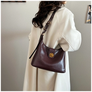 Detail of dark red vintage underarm bag with gold ring buckle and adjustable strap