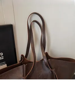 Detail of vintage brown leather tote bag showing comfortable shoulder straps and textures