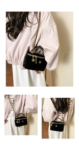 Detail of black velvet quilted crossbody bag with gold chain and luxury logo