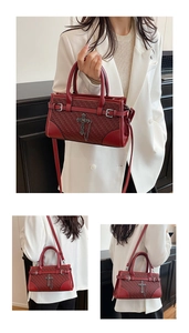 Detail of dark red crossbody bag featuring woven texture and gothic cross charm