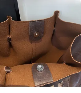 Close-up of magnetic snap closure and pebble grain texture on a vintage tote bag