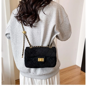 Détail du sac bandoulière noir matelassé avec chaîne dorée et fermoir métallique carré