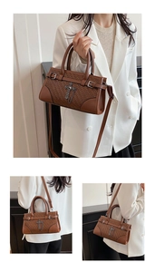 Close-up of brown woven leather handbag with decorative metal cross and chain details