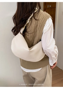 Vue détaillée d'un sac hobo crème avec chaîne dorée rétro porté par un modèle