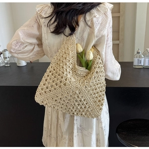 Detail of handwoven beige crochet tote bag with intricate diamond knit patterns