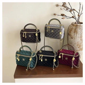 Macro shot of quilted velvet mini bags in various colors with golden chain straps