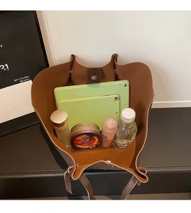 Internal view of brown leather tote bag showing large capacity for tablet and daily items