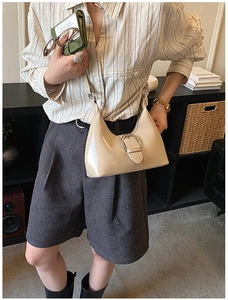 Détail du sac sous le bras beige en forme de lune avec boucle en métal argenté