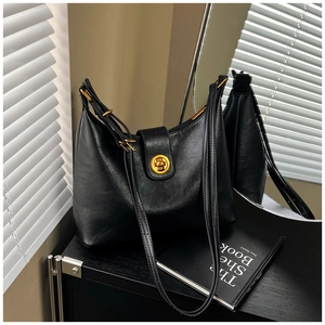 Detail of vintage black leather hobo bag with a circular golden twist-lock closure
