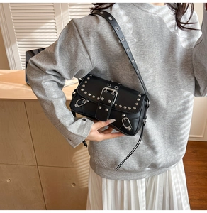 Detail of black Y2K shoulder bag featuring silver rivets and metallic buckle accents