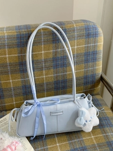 Light blue retro baguette bag with ribbon bow and star charm on plaid background