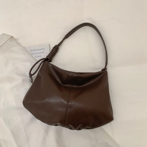 Detail of dark coffee brown tote bag with unique leather knot strap and pleated texture