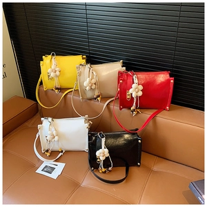 Colorful mini crossbody bags in five shades displayed on a brown leather sofa decor