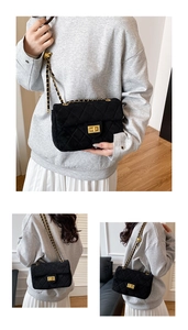 Détails d'un sac bandoulière noir matelassé avec fermoir doré et bandoulière chaîne