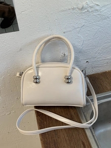 Sac Boston en cuir verni blanc avec boules métalliques argentées et logo tendance