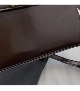 Dettaglio della borsa in pelle testa di moro con chiusura dorata e logo moda stampato