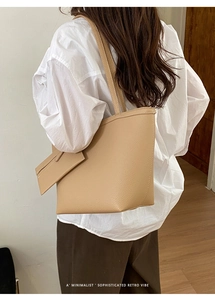Minimalistische beige Tote Bag mit kleiner Tasche, getragen von einem Modell im weichen Licht