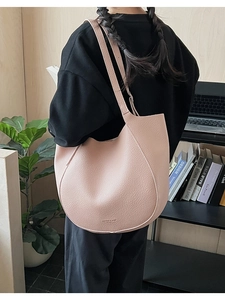 Detail of soft peach leather tote bag with lychee grain texture and fashion logo