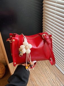 Chic red patent leather crossbody bag with gold rivets and white flower charm