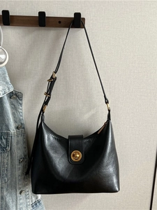 Minimalist black leather hobo bag with adjustable strap and golden turn-lock closure