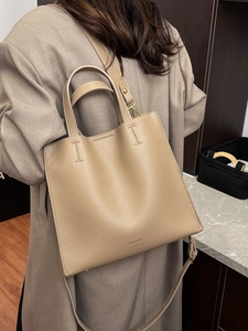 Minimalist khaki litchi leather tote bag with top handles and adjustable shoulder strap