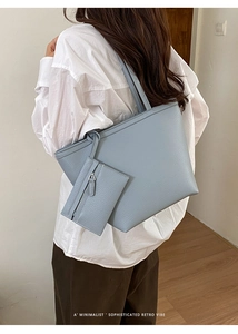 Detailaufnahme der graublauen Ledertasche mit Narbenstruktur und passender kleiner Tasche