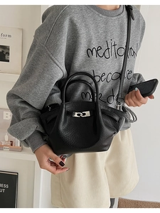 Detail of black lychee grain leather bucket bag with silver chain metal clasp