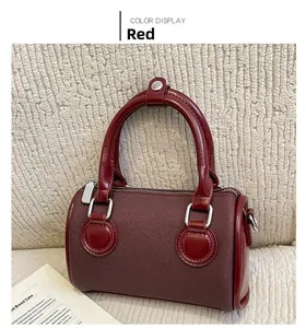 Detail view of burgundy Boston handbag featuring dual handles and silver zipper hardware