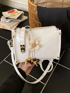 Chic white patent leather crossbody bag with knit flower charm and golden square lock