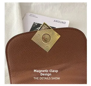 Détail du fermoir magnétique doré sur un sac à main en cuir marron grainé