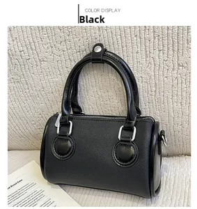 Close-up of black knit Boston bag featuring sleek faux leather handles and silver hardware