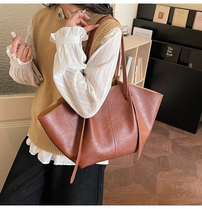 Detail of vintage brown tote bag showing matte faux leather texture and sturdy stitching