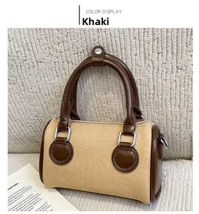 Detail of khaki Boston bag with dark brown leather trim and metallic D-ring buckle