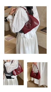 Détail d'un sac sous le bras en cuir verni bordeaux avec boucle fer à cheval argent