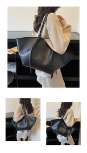 Detail view of large black retro tote bag in PU leather carried on shoulder by model