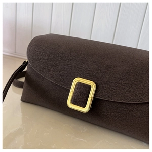 Detail of dark brown cracked leather handbag with elegant golden metal buckle closure