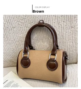 Detail view of the brown canvas Boston bag with leather trim and silver metal hardware