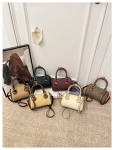 Multiple colors of stylish Boston handbags arranged on a beige textured carpet