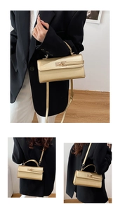 Detail of trendy gold handheld bag with metallic rotating lock and cross-body strap