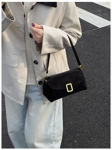 Chic black matte shoulder bag featuring a vintage gold square buckle in a street style setting