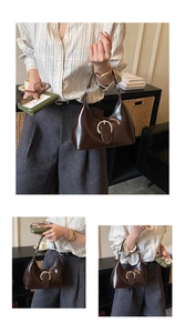 Détail d'un sac à main en cuir marron foncé brillant avec une boucle en métal argenté