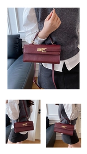 Detail of burgundy baguette bag with gold twist lock and adjustable crossbody strap