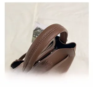Détail du sac seau en cuir avec boucle argentée et pendentif ours en peluche