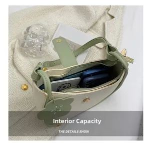 Detail view of contrast color bucket bag interior capacity with flower charm