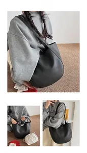 Detail of black pebbled leather tote bag with internal drawstring pouch and shoulder strap