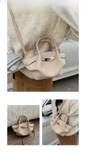 Detail of beige lychee grain leather bucket bag with silver twist lock and strap